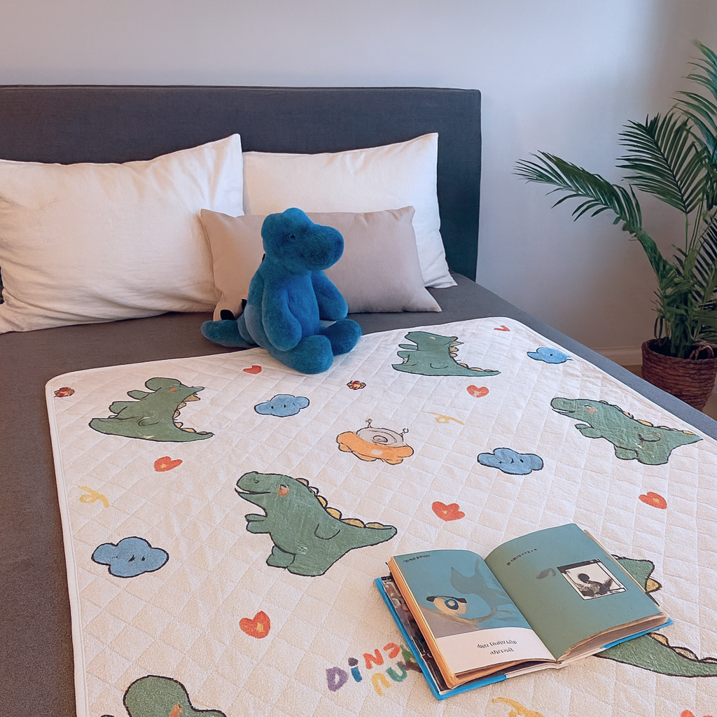 Waterdichte bedonderlegger met dinosaurusprint op een kinderbed