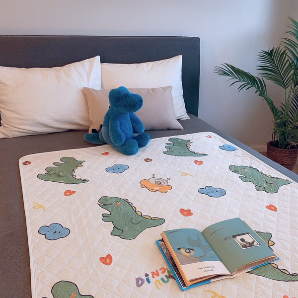 Waterdichte bedonderlegger met dinosaurusprint op een kinderbed